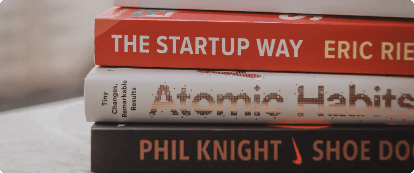 A stack of popular business startup and self-improvement books.