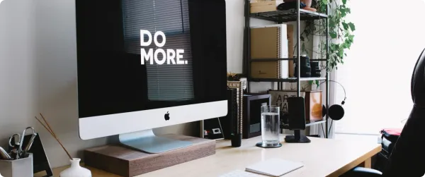 Modern workspace with an iMac displaying the words, Do More.