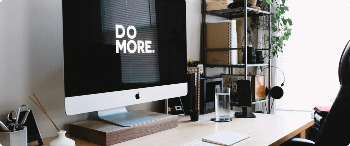 Modern workspace with an iMac displaying the words, Do More.