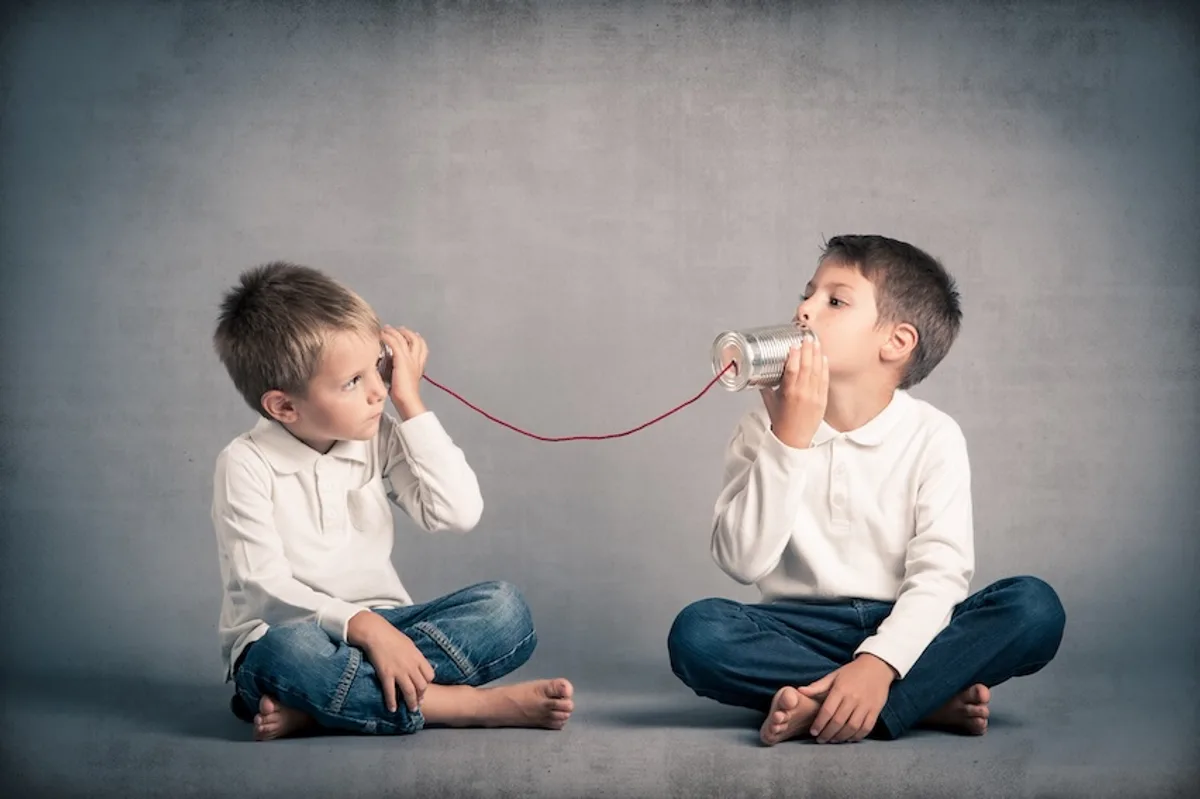 Young boys using a tin can telephone, symbolizing secure and compliant communication in email marketing.