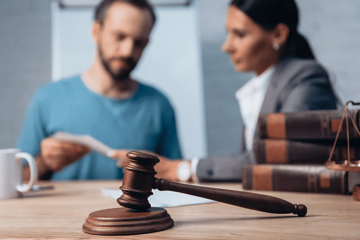 Judge's gavel, law books, and scale with individuals discussing legal documents, symbolizing email compliance