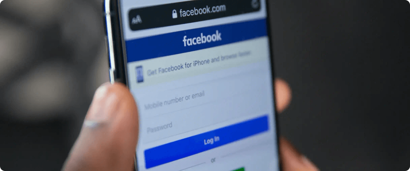 A close-up of a smartphone displaying the Facebook login page.