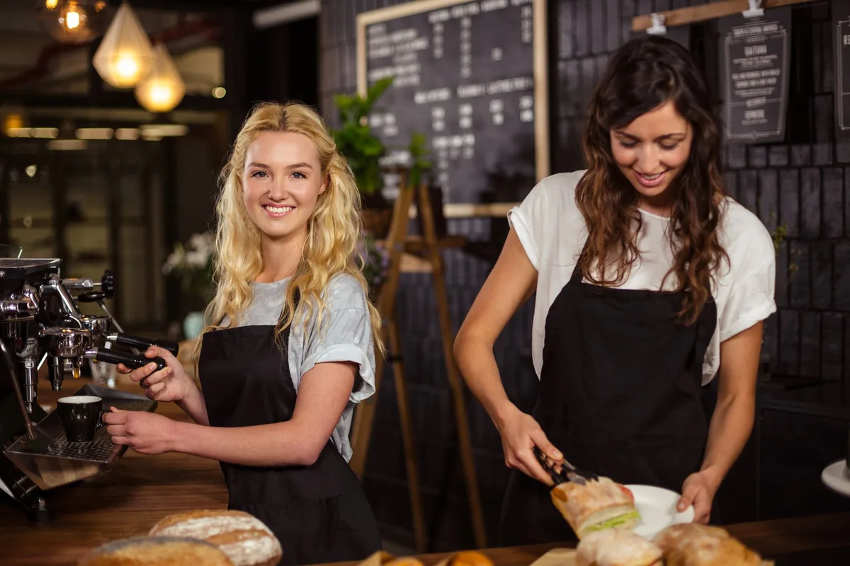 Two café owners making coffee and sandwiches, illustrating a specific target audience for tailored email marketing.