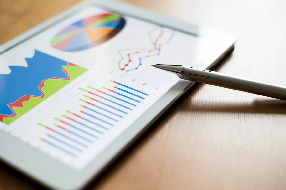 Digital tablet on a desk displaying analysis data and graphs, illustrating the role of email marketing analytics in enhancing customer engagement and identifying cross-selling and upselling opportunities.