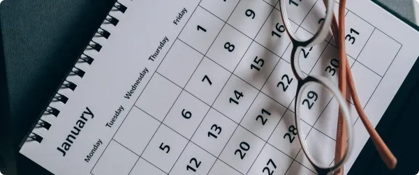 A calendar with glasses on top, representing email timing.