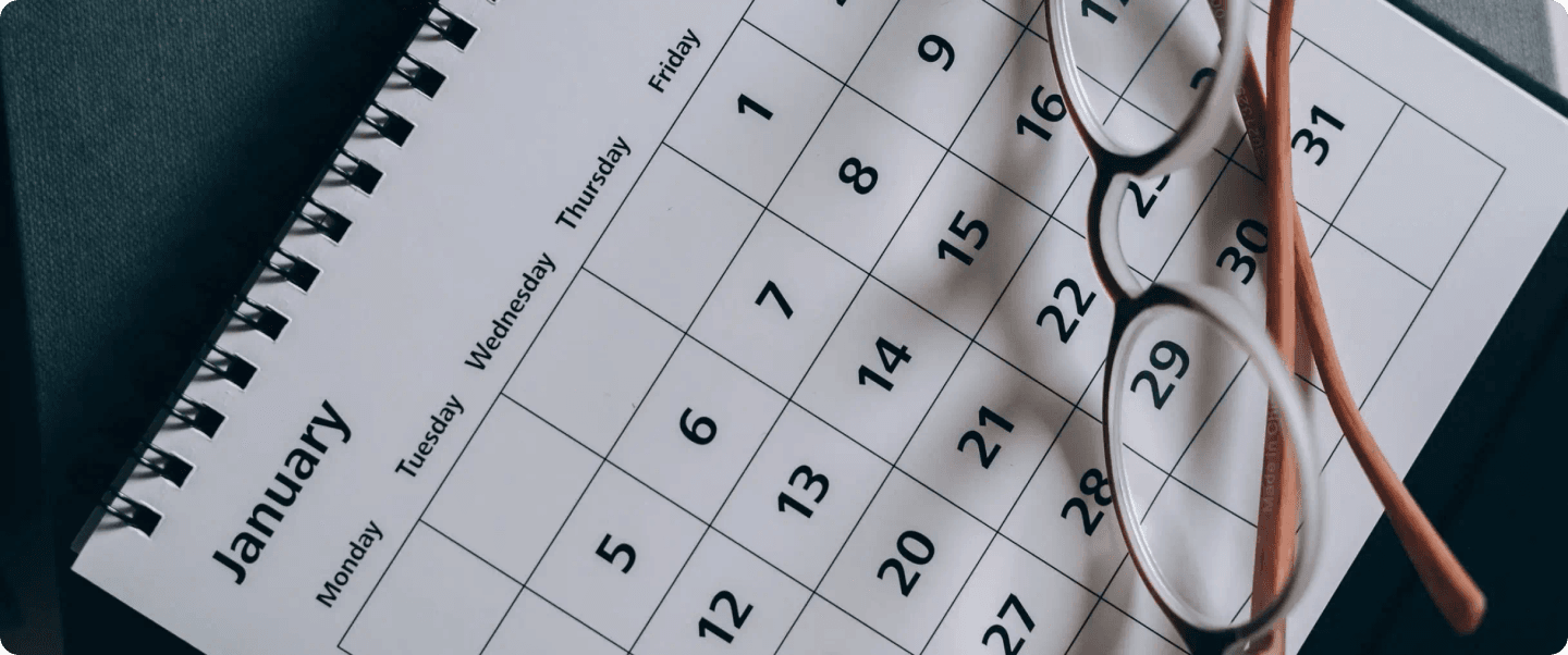 A calendar with glasses on top, representing email timing.