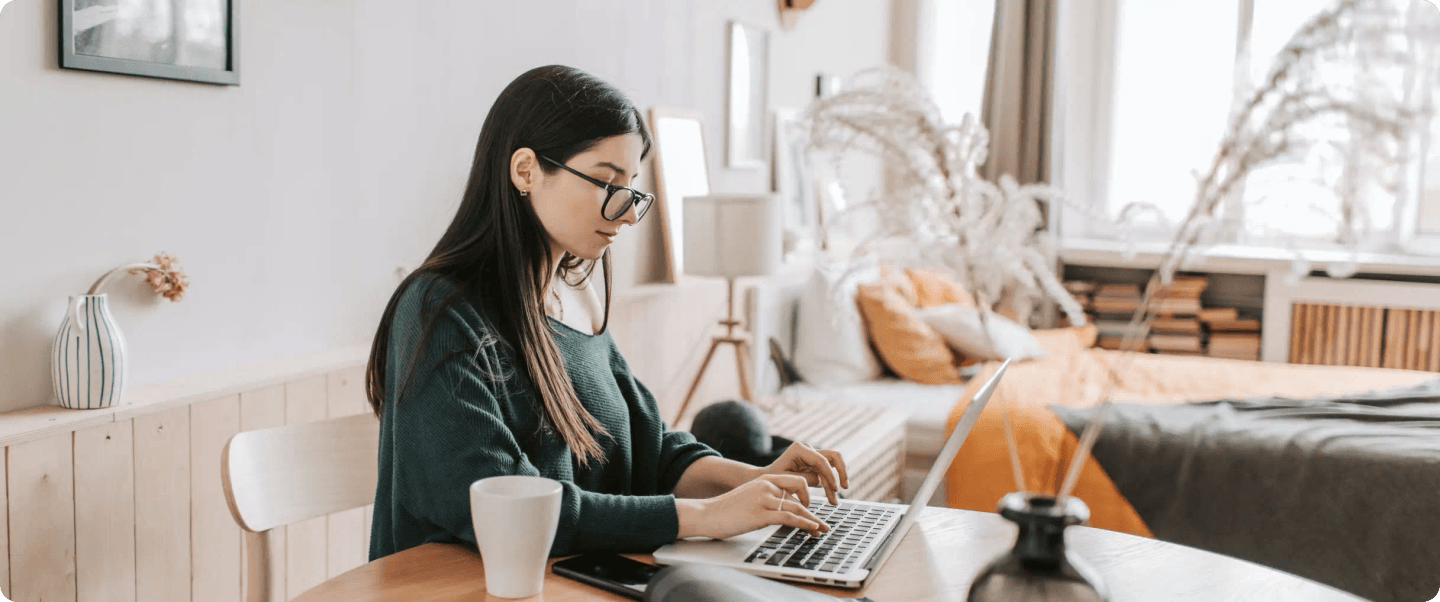 A woman working in a home office, coming up with ideas for an email newsletter.