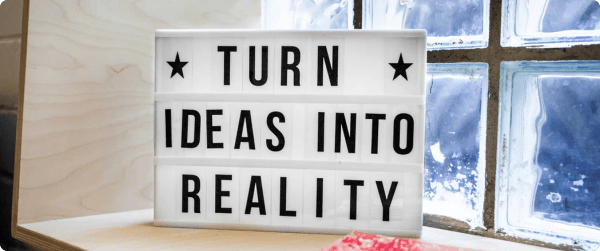 A sign with the words, TURN IDEAS INTO REALITY, printed on it.