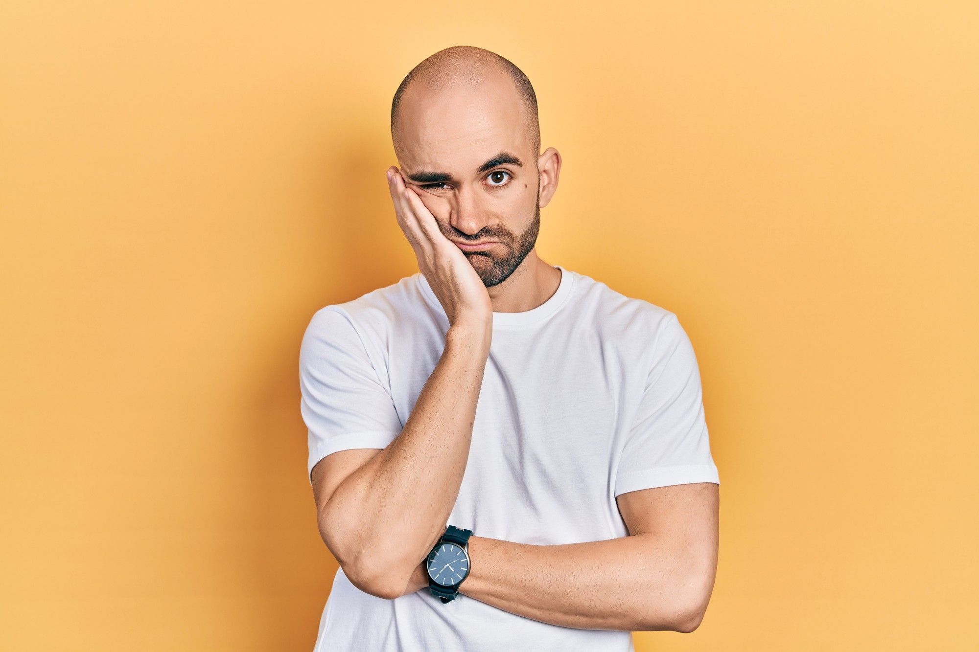 Frustrated man holding his face, illustrating customer pain points and confusion.