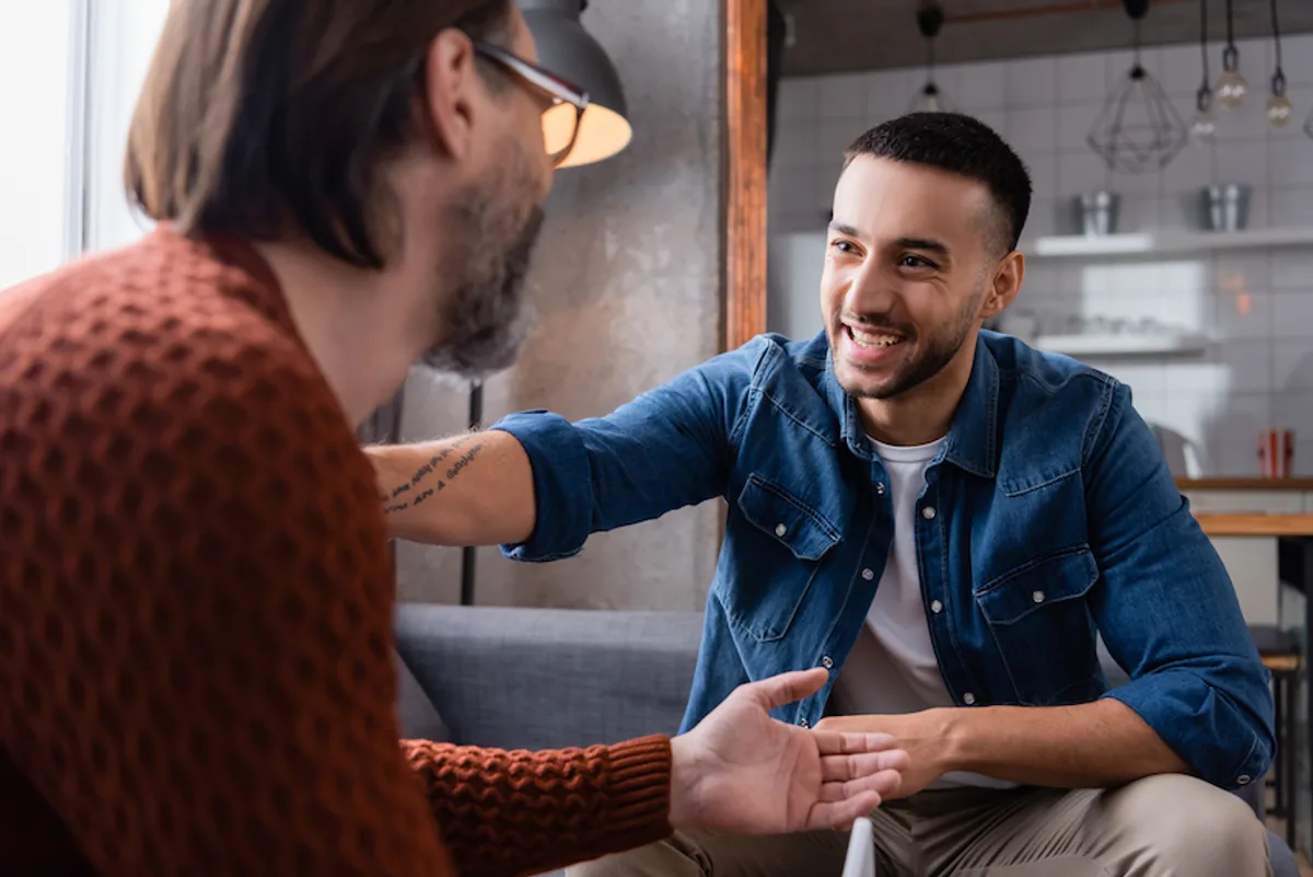 Two smiling small business owners engaging in a direct, positive conversation, symbolizing effective customer communication.