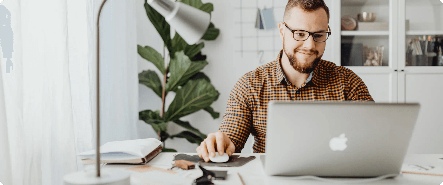 A person working on their laptop in a home office.